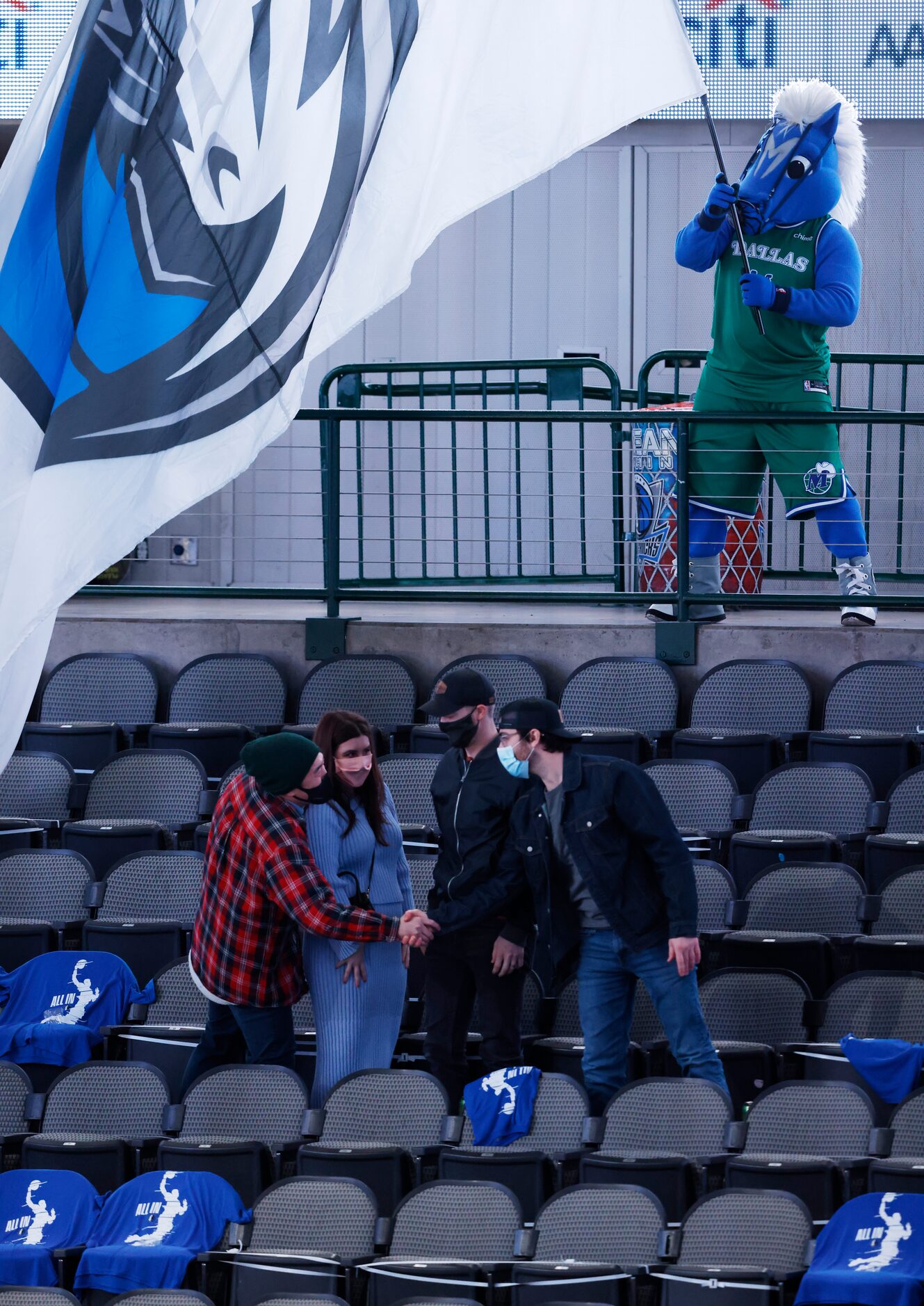 Dallas Mavericks mascot Champ waves the flag in front of  fans in attendance before the...