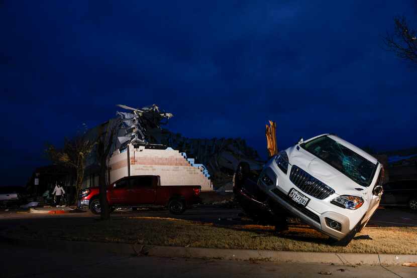 A car rests on a tree stump after a possible tornado at Jacksboro Elementary in Jacksboro,...