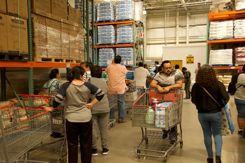At a Costco in Ciudad Juarez, Mexico, people line up to receive rations of the store's stock...