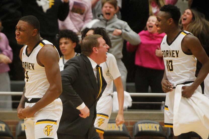 Forney head coach Bart Holloway, center, is framed by players Ameare Owens (4), left, and...