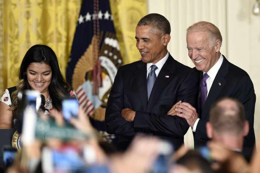  President Barack Obama, center, standing with Vice President Joe Biden, right, listens as...