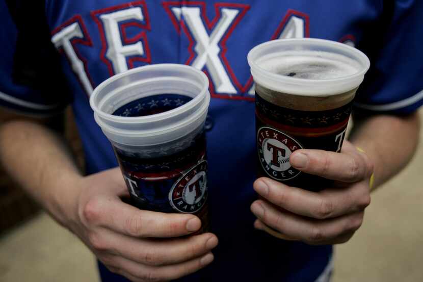Hutch Hutchison holds onto a couple of beers  during opening day of Texas Rangers baseball...