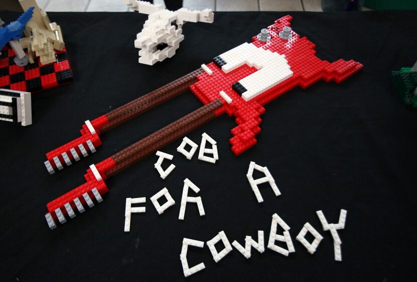 A Lego double neck guitar created by Adam Skroh, complete with a skull, to left, which is...