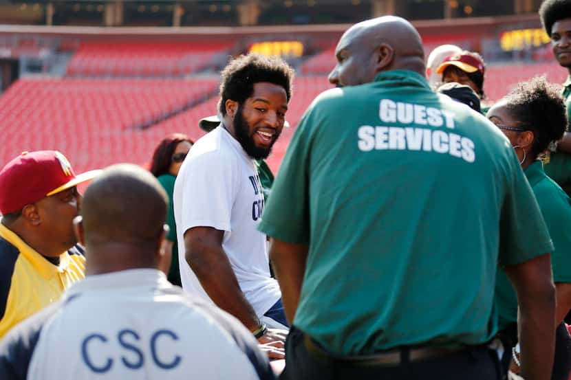 Dallas Cowboys running back Alfred Morris (46) visits with stadium employees before a game...