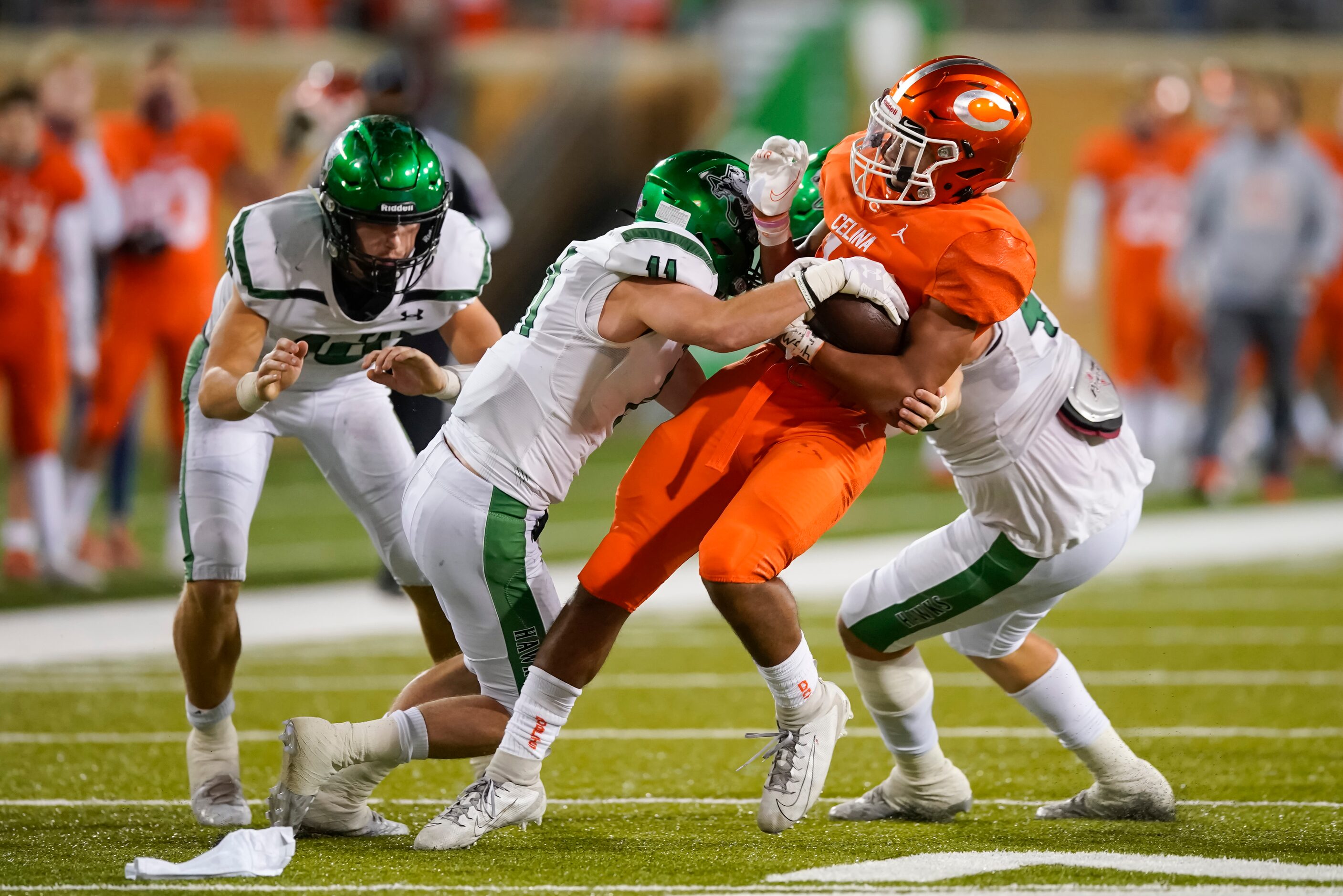 Celina running back Trae Hollins (14) is bought down by Iowa Park defensive back Tom Garrett...