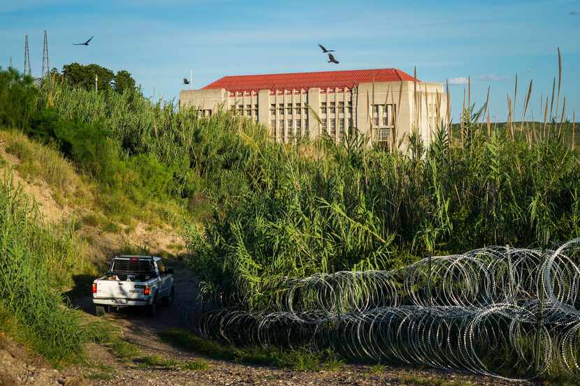 A vehicle drives past concertina wire fencing on the grounds of the Travis D. Kelly...
