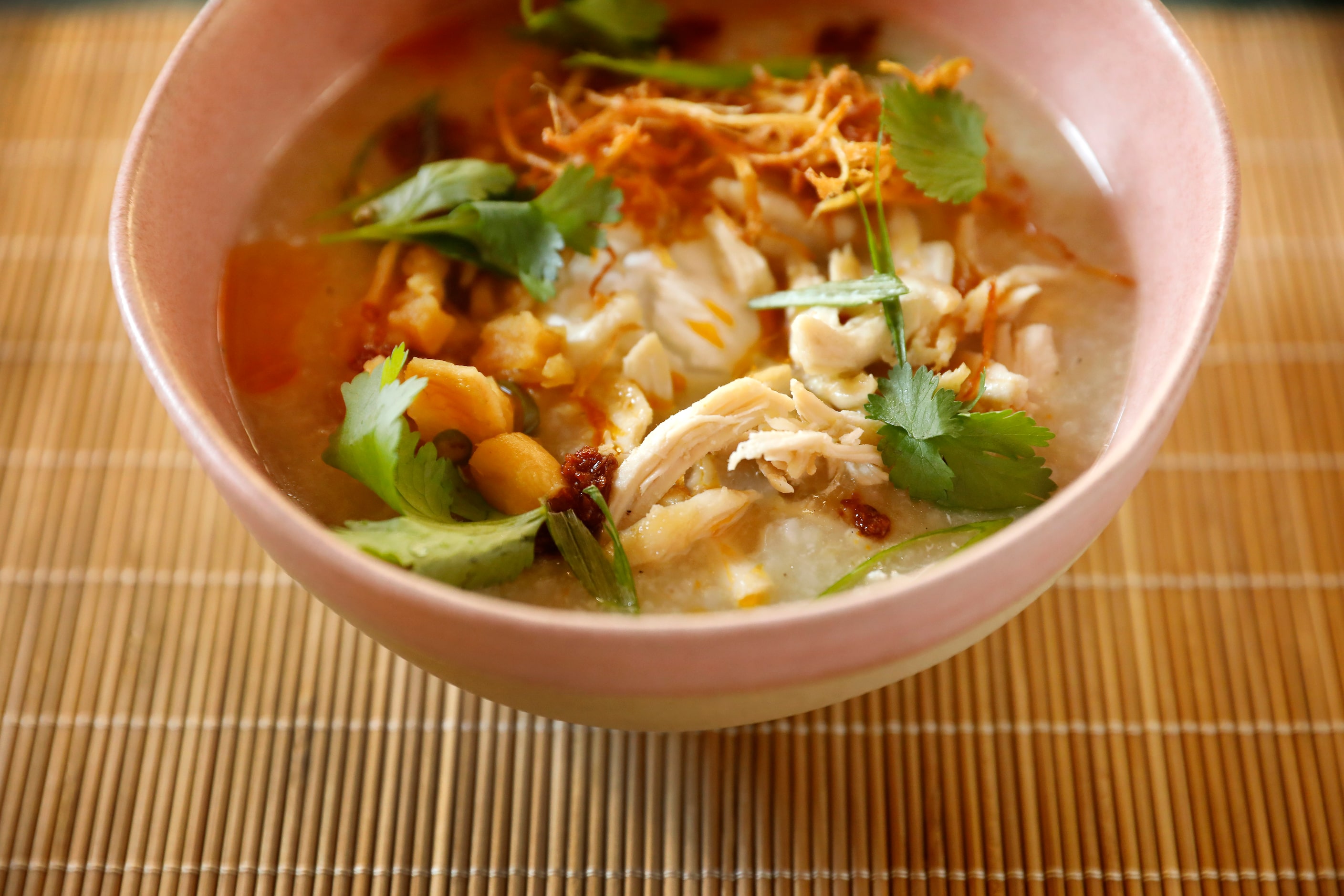 Congee made with shredded chicken, poached egg, ginger crisp and pickled daikon at Rose Café...