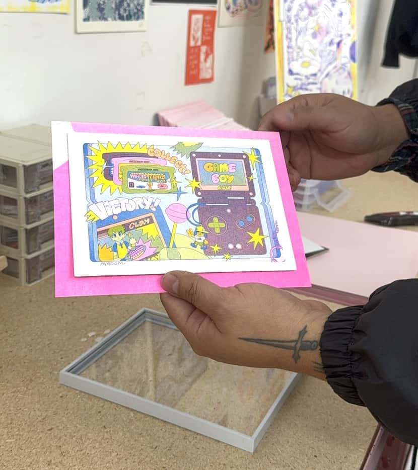 Play Nice Press co-founder Jacob Vasquez holds a risograph print by illustrator Ava Pom....