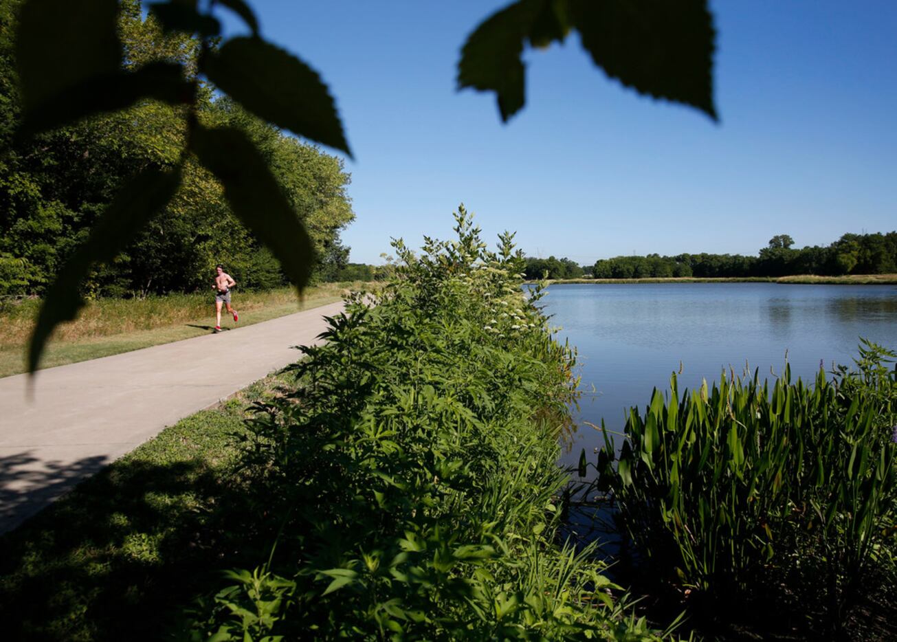 Jason Gates runs along the trail at Oak Point Park and Nature Preserve in Plano, Texas on...