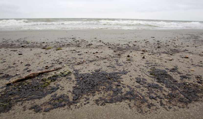 A black sticky oily substance was washing up along the beach at the Texas City Dike near the...
