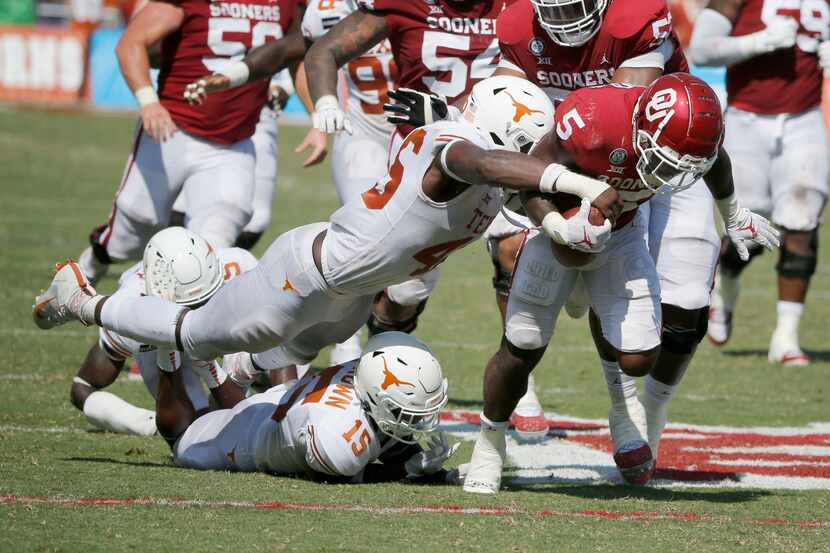 FILE - Texas linebacker Joseph Ossai (46) forces a fumble by Oklahoma running back T.J....