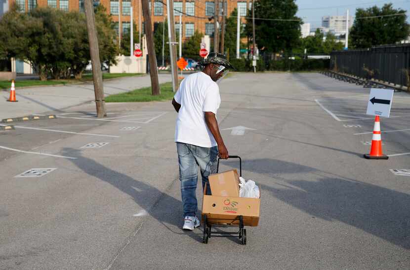 Elbert Anderson of Dallas makes his way toward the exit after picking up food in the walk-up...