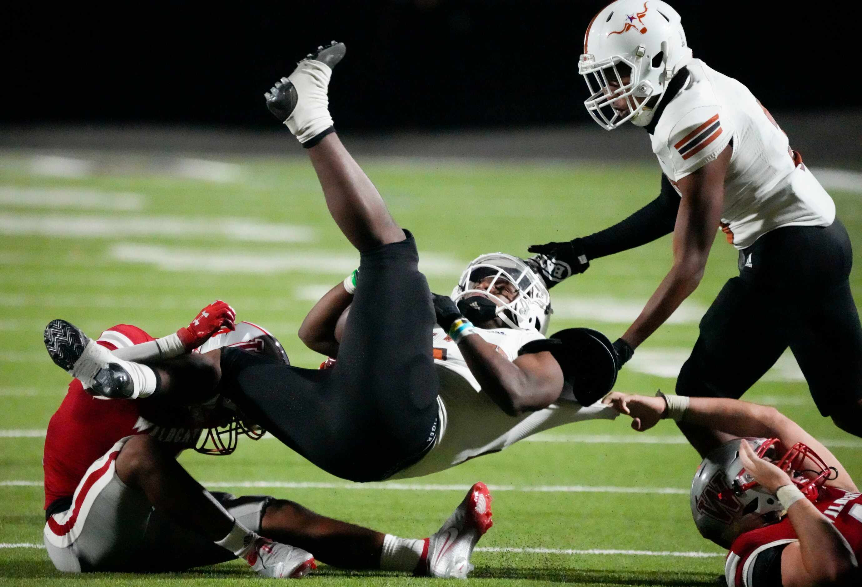 W.T. White Daviawn Bishop, center, is tackled by Woodrow Wilson senior defensive lineman...