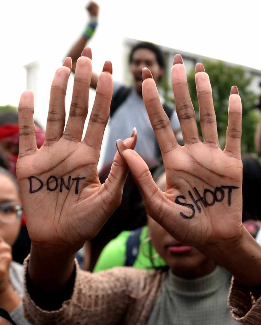 A woman displays her hands during a rally/prayer vigil at Marshall Park in Charlotte, N.C.,...