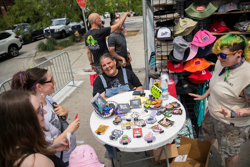 Kelly Saunders (center) laughs while checking a customer out at the Everything Ellum booth...