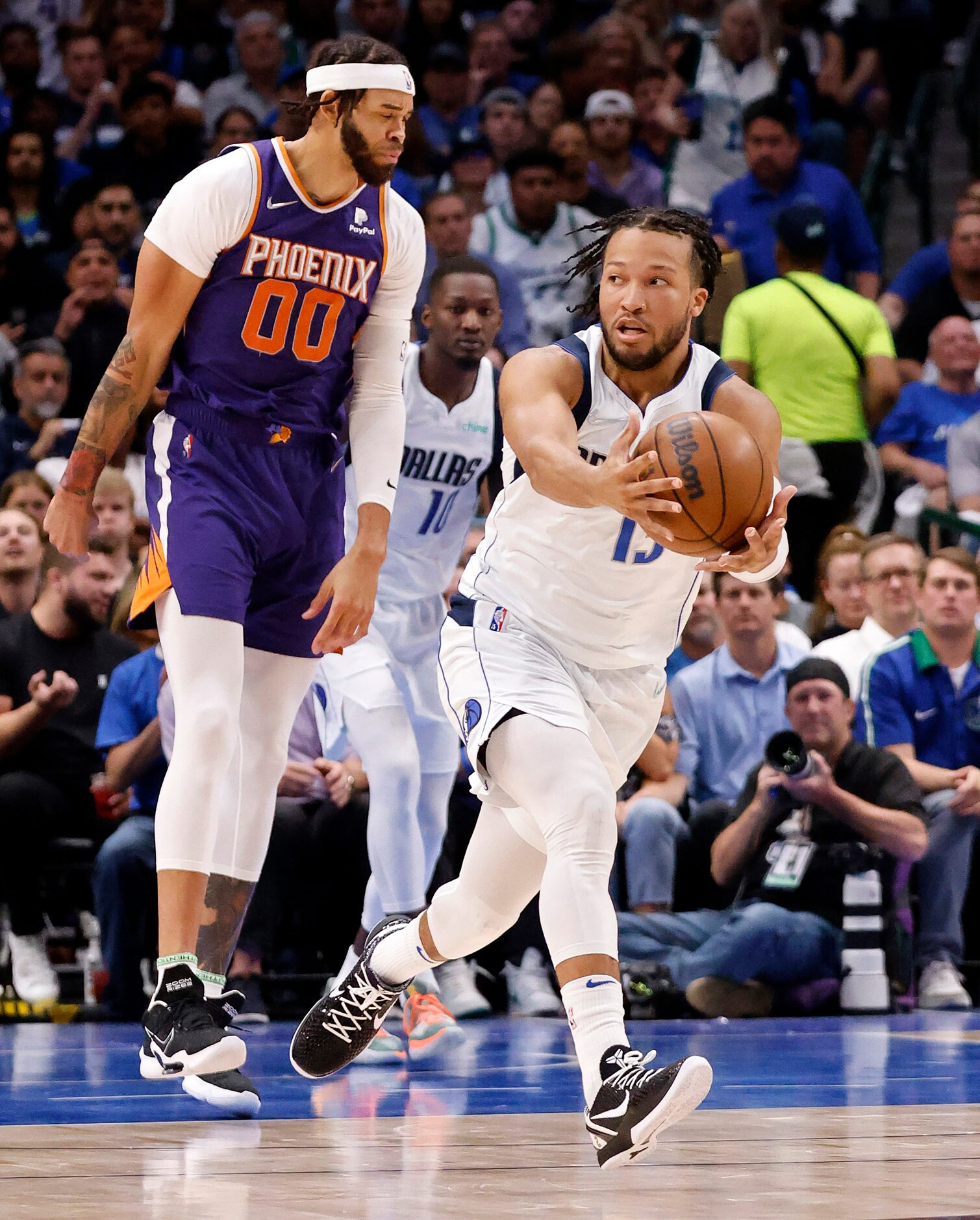 Dallas Mavericks guard Jalen Brunson (13) picks up a loose rebound against Phoenix Suns...