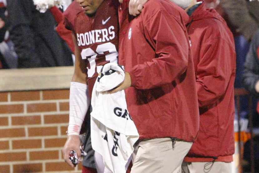Oklahoma Sooners player Trey Millard is helped off the field after being injured in a play...