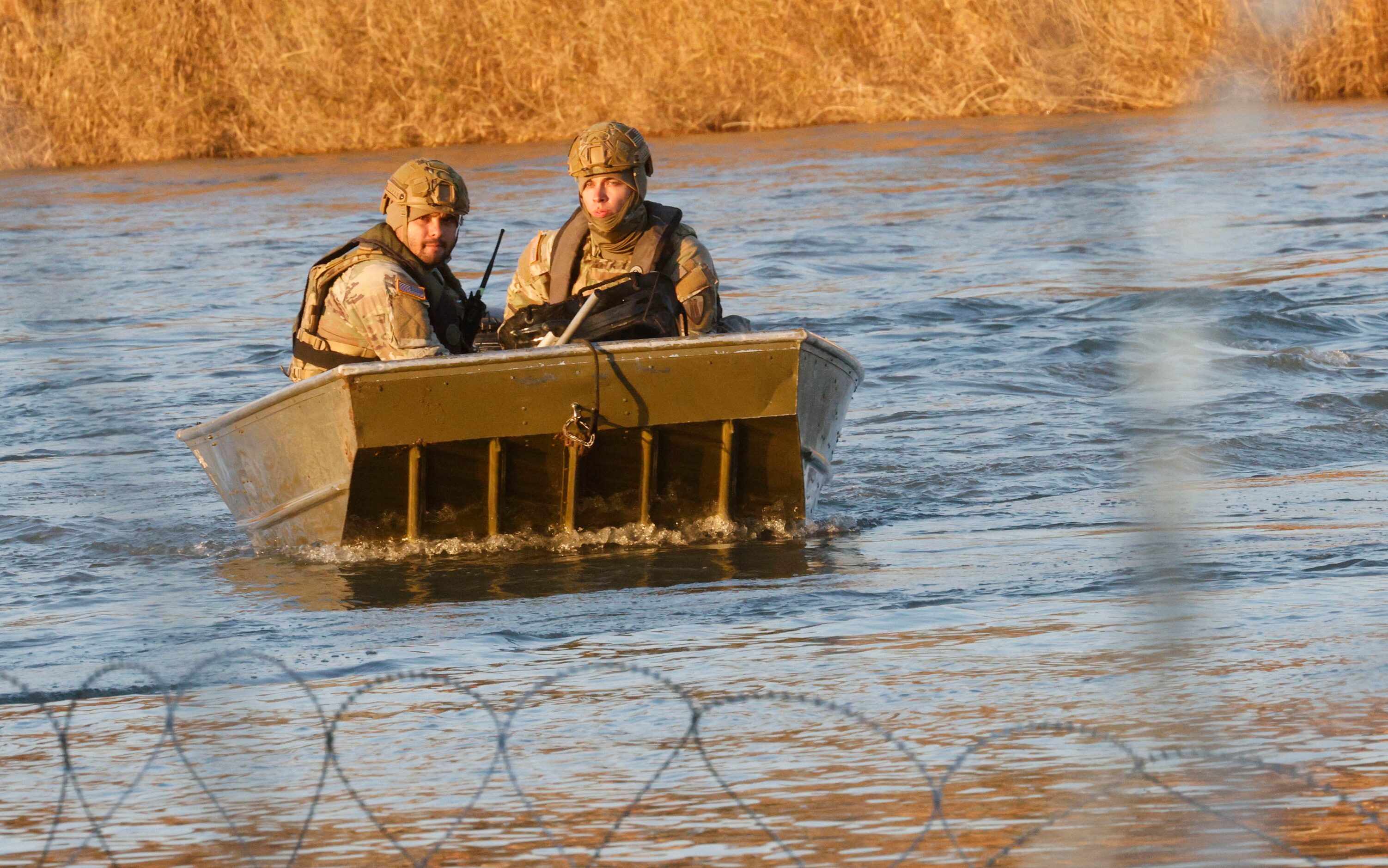 Texas National Guard soldiers ride a boat on the Rio Grande at the Shelby Park area,...