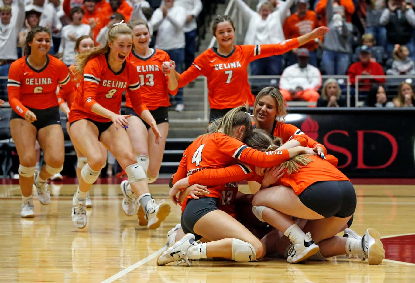 Celina players, including Lily Neidhart (4) collapse on the floor, as the jubilant bench,...