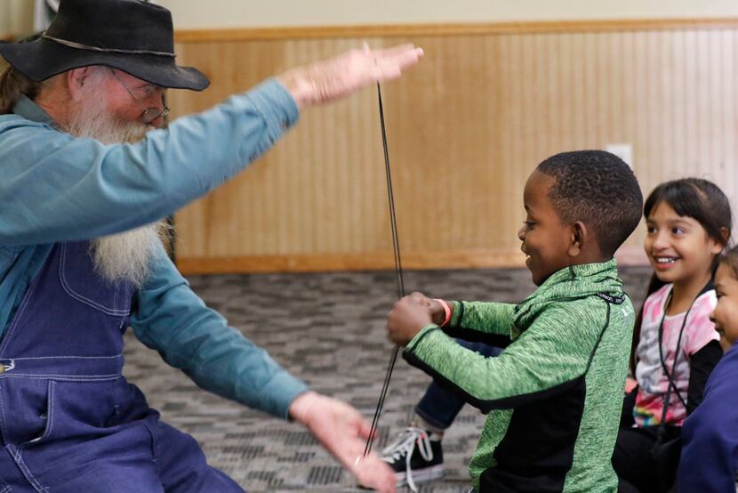 Gene Helmick-Richardson, with Twice Upon a Time Storytellers performs a trick with Cameron...