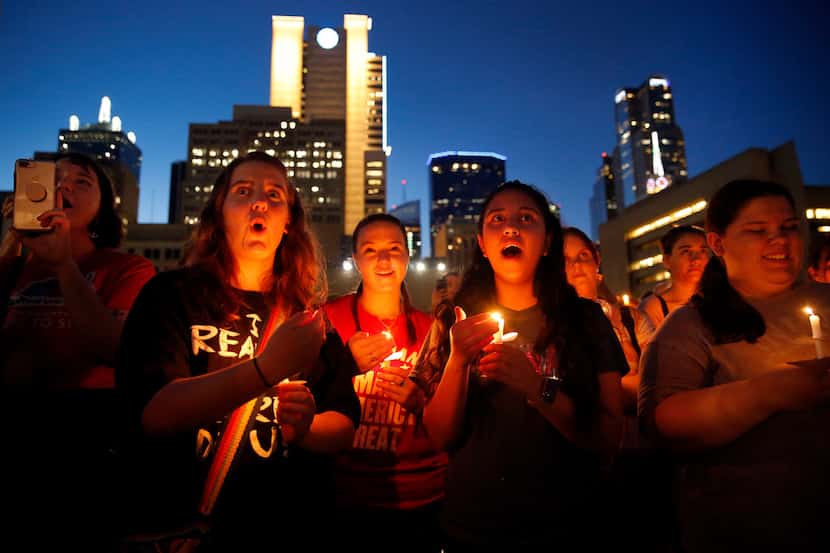 Katy Schneider (from center left), Alison Earnhart and Kathia Suarez of Denison chant with...