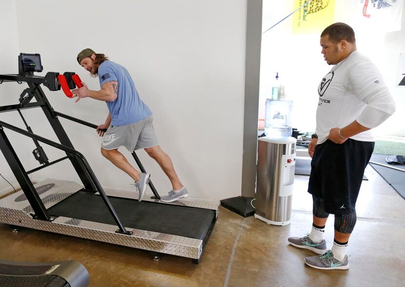 David Vobora,  owner of Performance Vault, hops on a treadmill to show James Castleman, a...