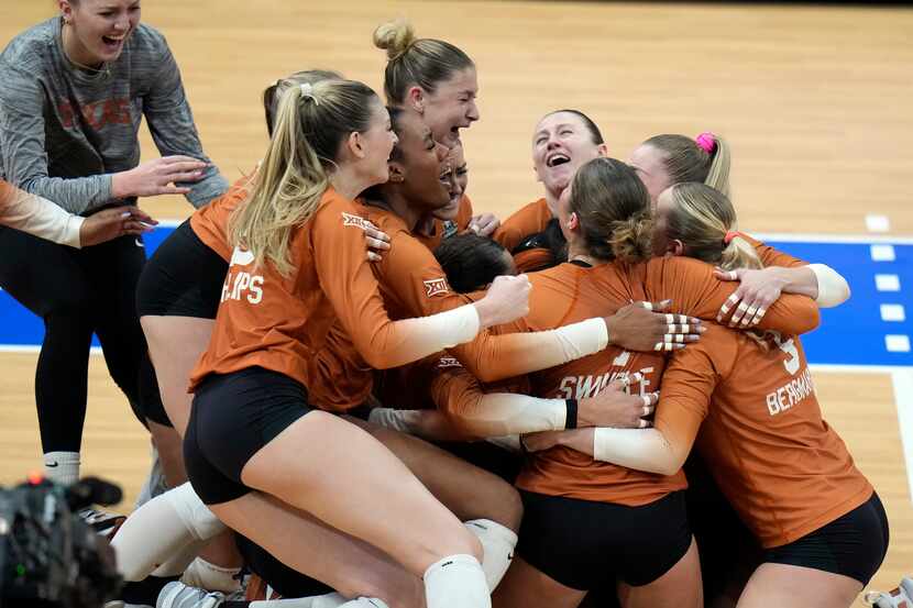 Texas players celebrate after winning the NCAA Division I women's college volleyball...