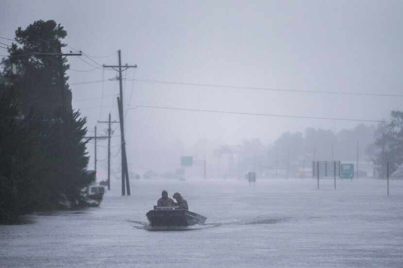 Emergency responders drive a boat across Highway 96 in flood waters from Hurricane Harvey on...