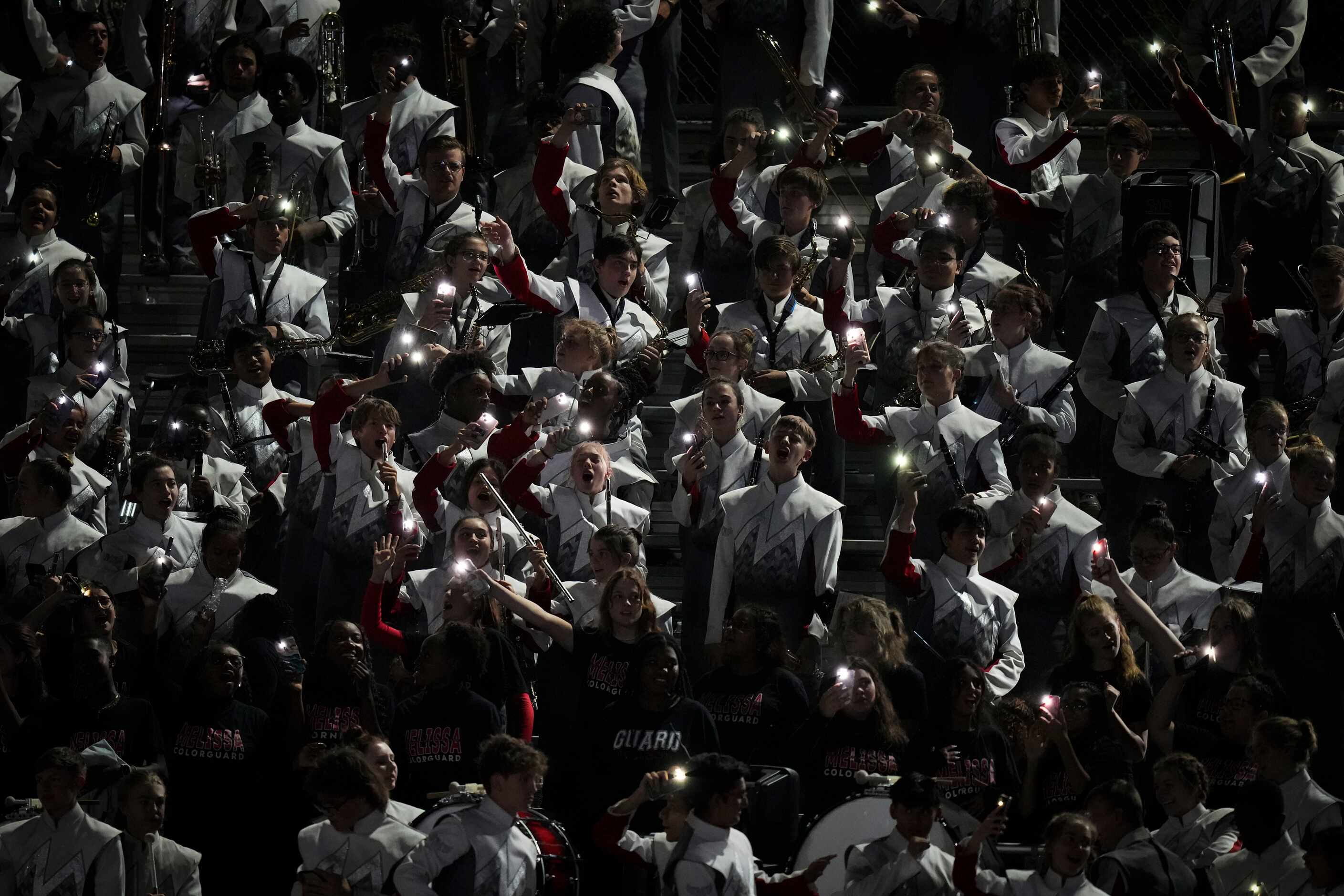 Members of the Melissa band hold up mobile phones as they participate in a Lovejoy crowd...