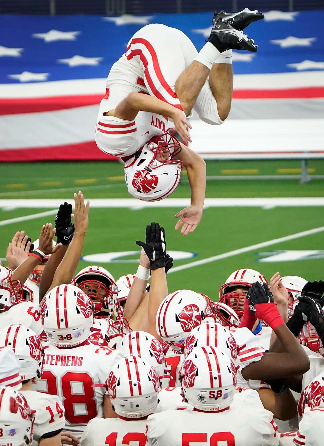 Katy defensive back Colton Cable (32) flips over his teammates as the team takes the field...