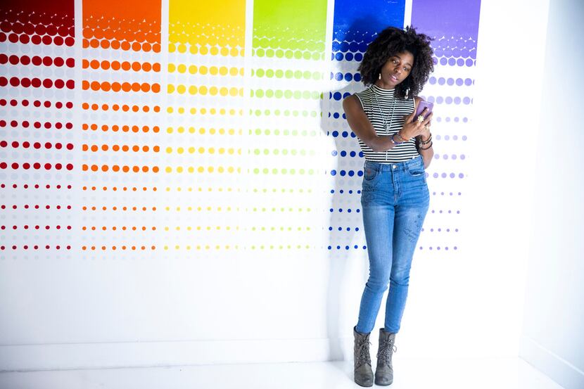 Chynna Oliver takes a photograph in front of a wall during a soft opening night at Rainbow...