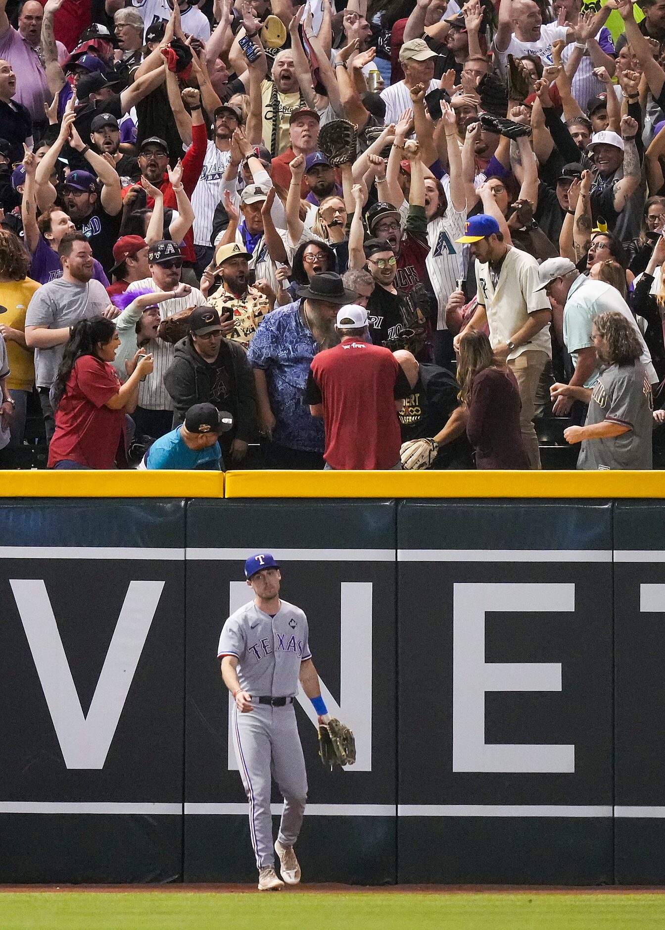 Texas Rangers left fielder Evan Carter looks away as Arizona Diamondbacks fans celebrate a...