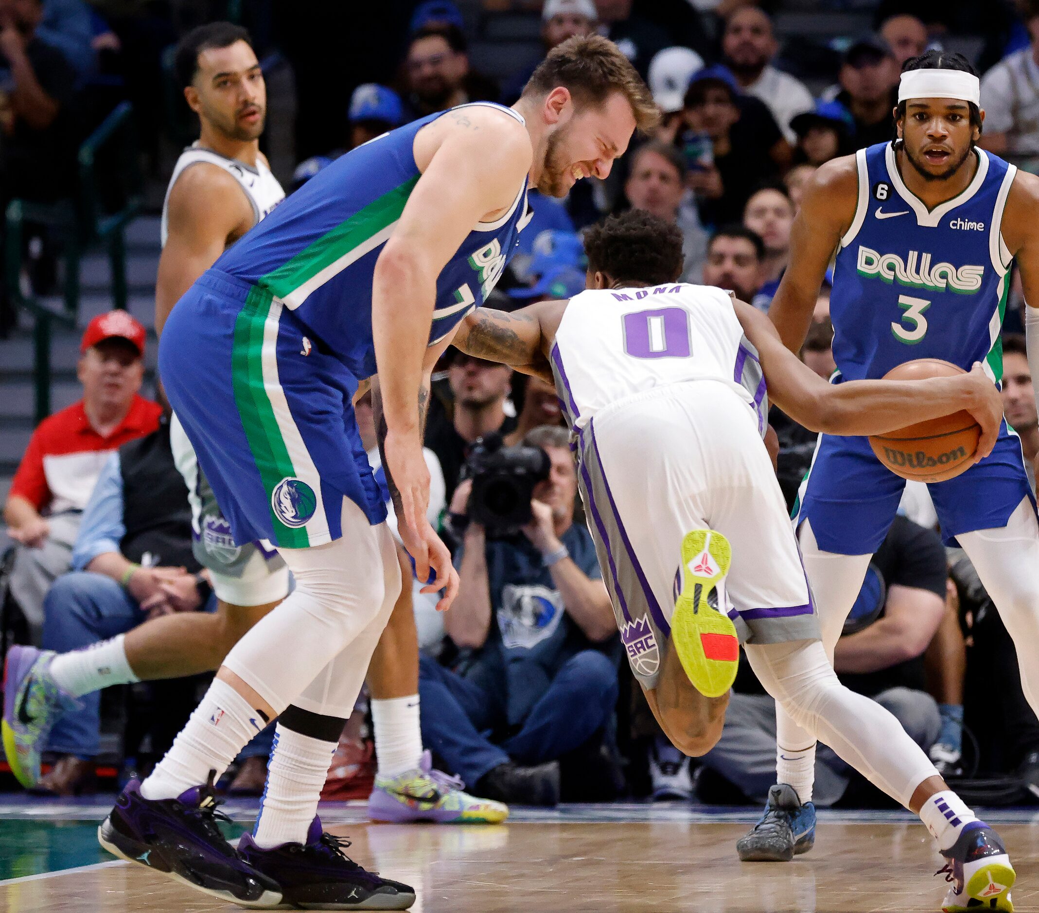 Dallas Mavericks guard Luka Doncic (77) grabs his left knee after colliding with Sacramento...