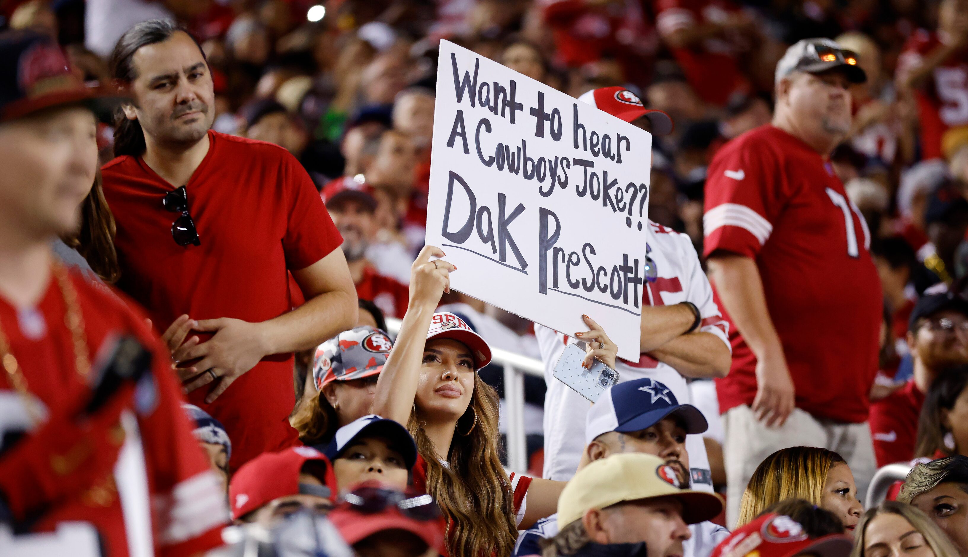 A San Francisco 49ers fan ask the question of Dallas Cowboys quarterback Dak Prescott (4)...