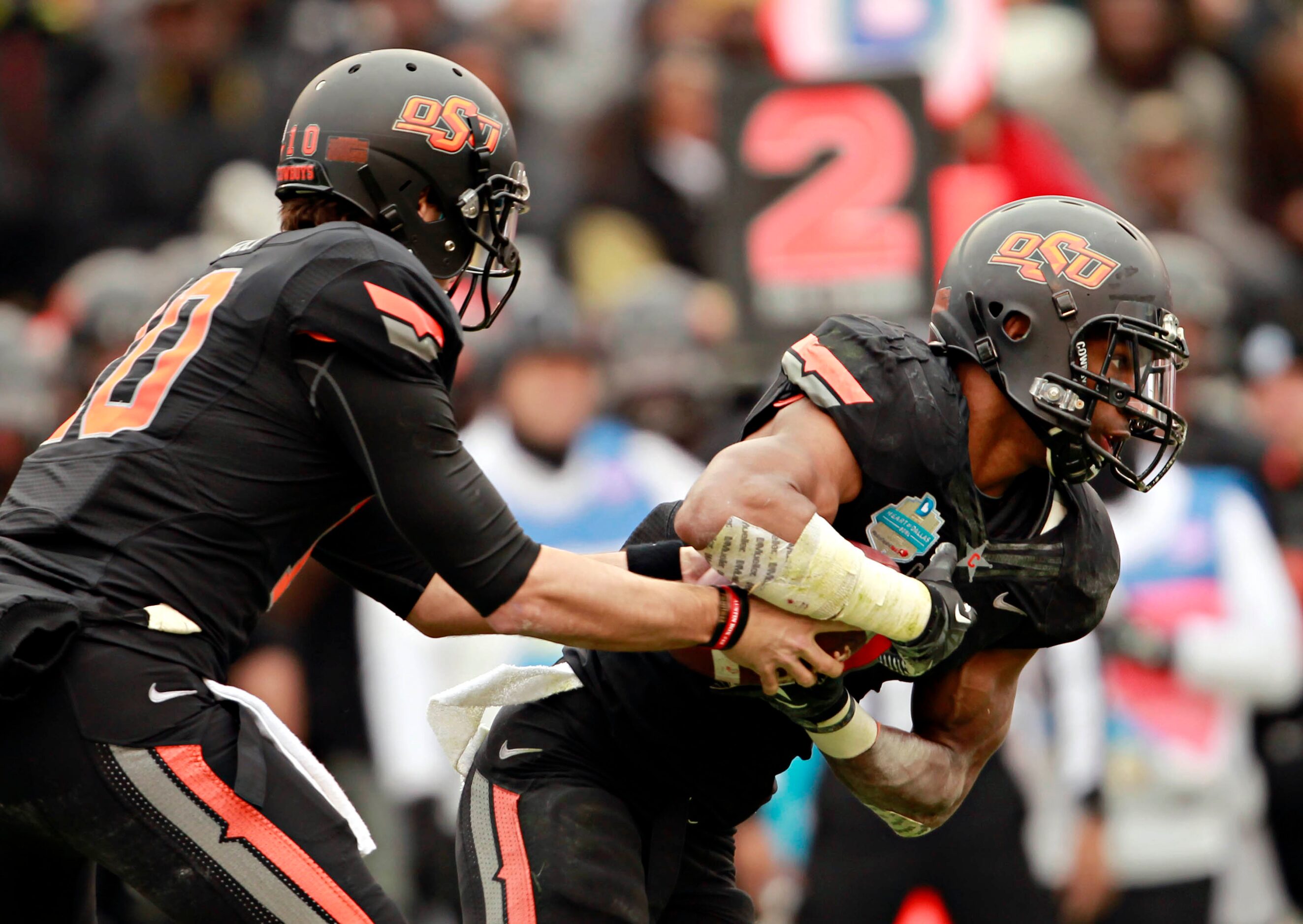 Oklahoma State Cowboys quarterback Clint Chelf (10) hands off to running back Joseph Randle...