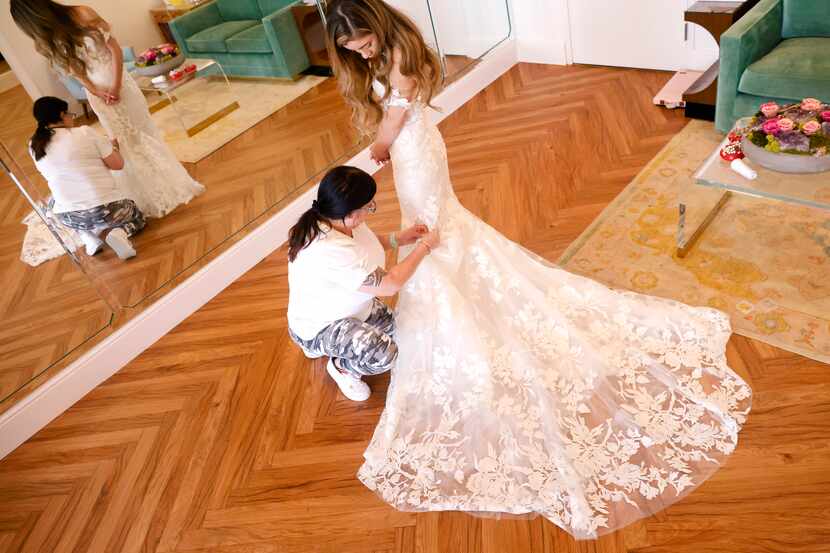Soon-to-be bride Lauren Garcia of Dallas watches as custom tailor Benita Rimi of Warren...