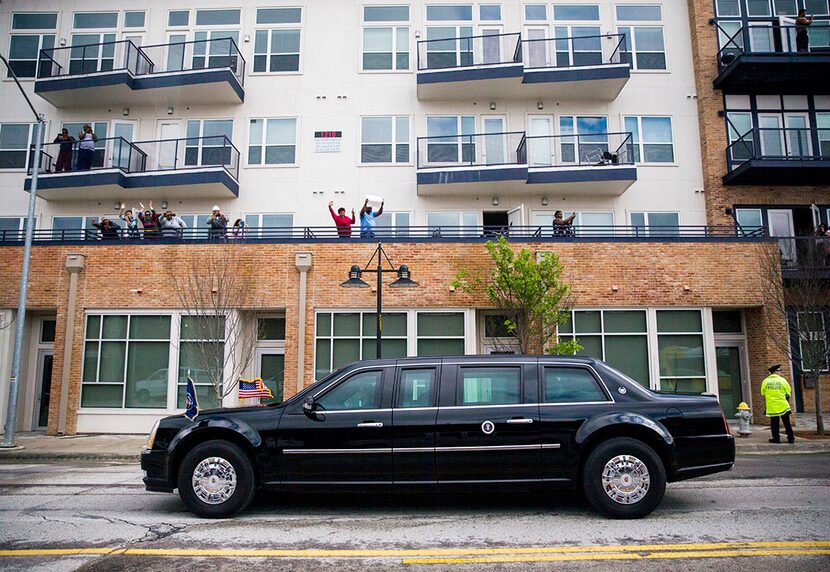  People cheer from apartment balconies as President Barack Obama passes in a presidential...