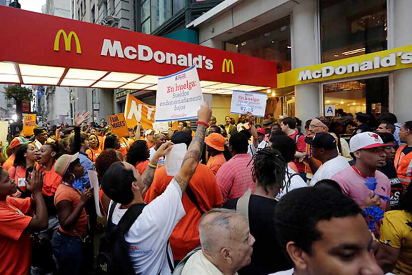 Protesters demonstrate outside a McDonald's restaurant Thursday on New York's Fifth Avenue...