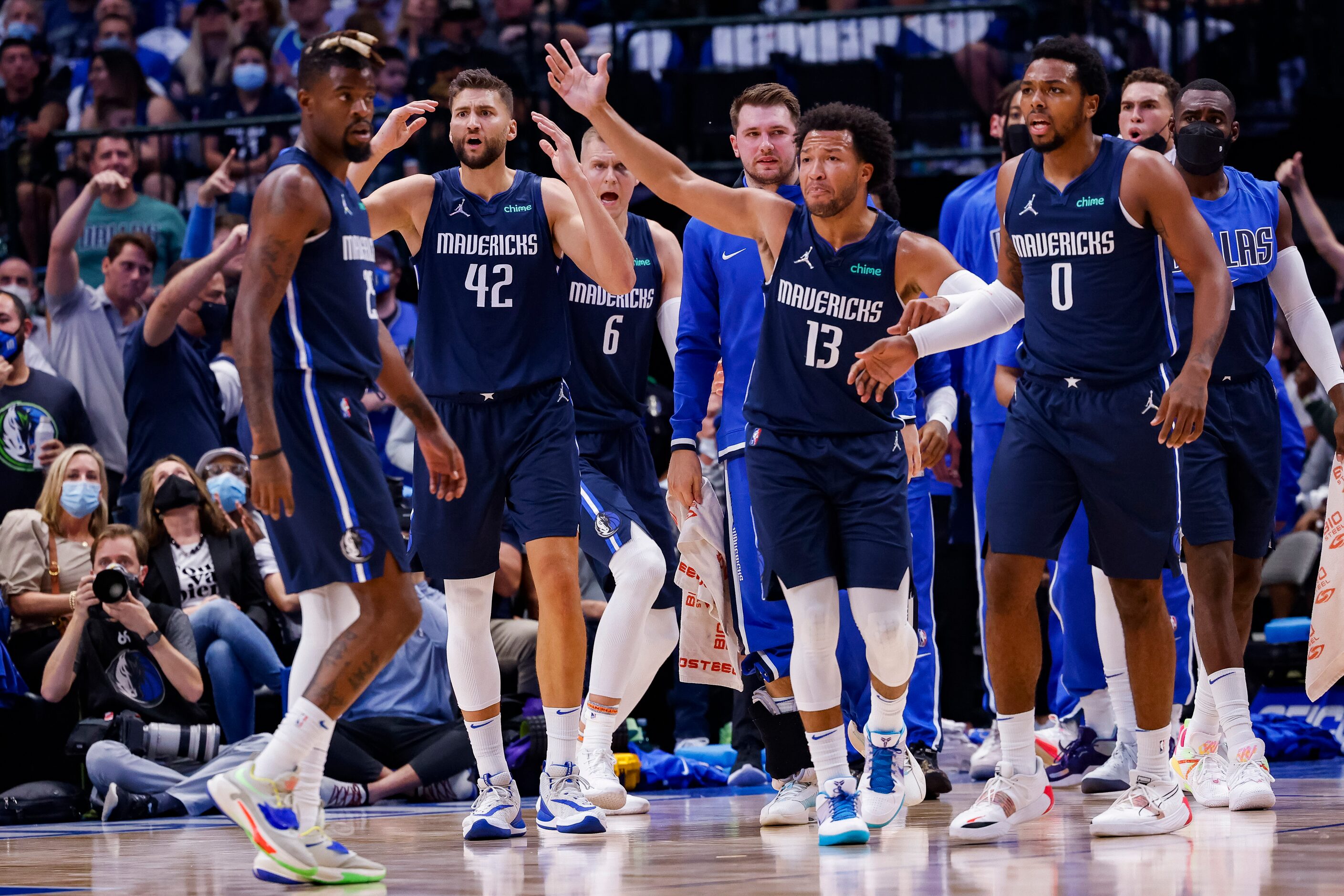 Players argue the refs call on a shot made by Dallas Mavericks center Kristaps Porzingis (6)...