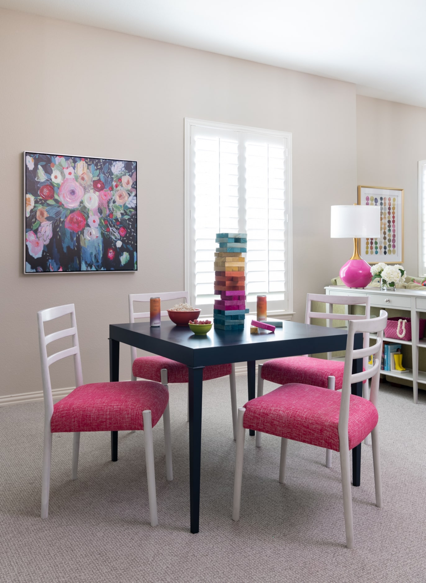 Nicole Arnold chose pops of pink for the seats of the chairs at this game table.