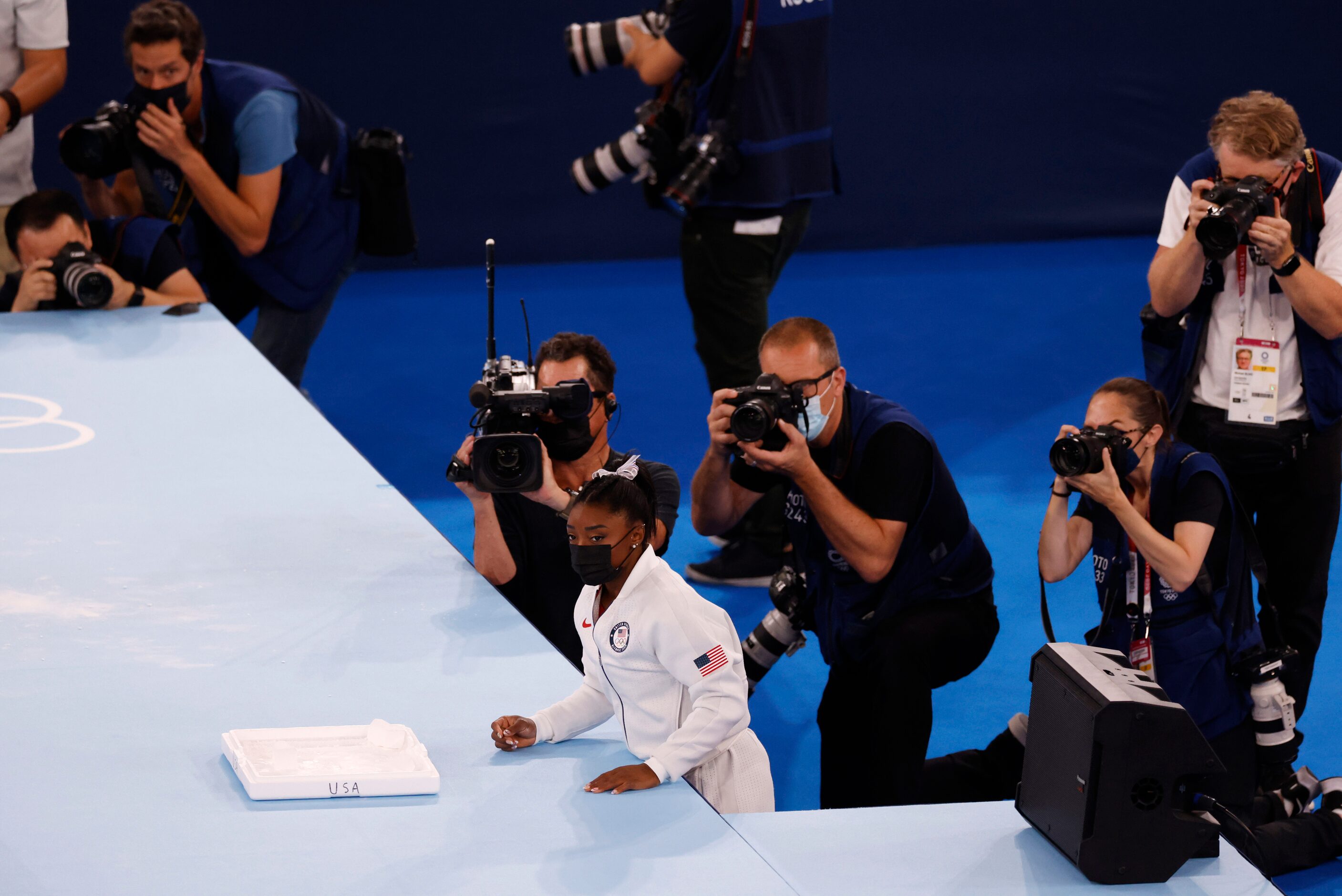 USA’s Simone Biles watches after placing the chalk out for her teammates before they...