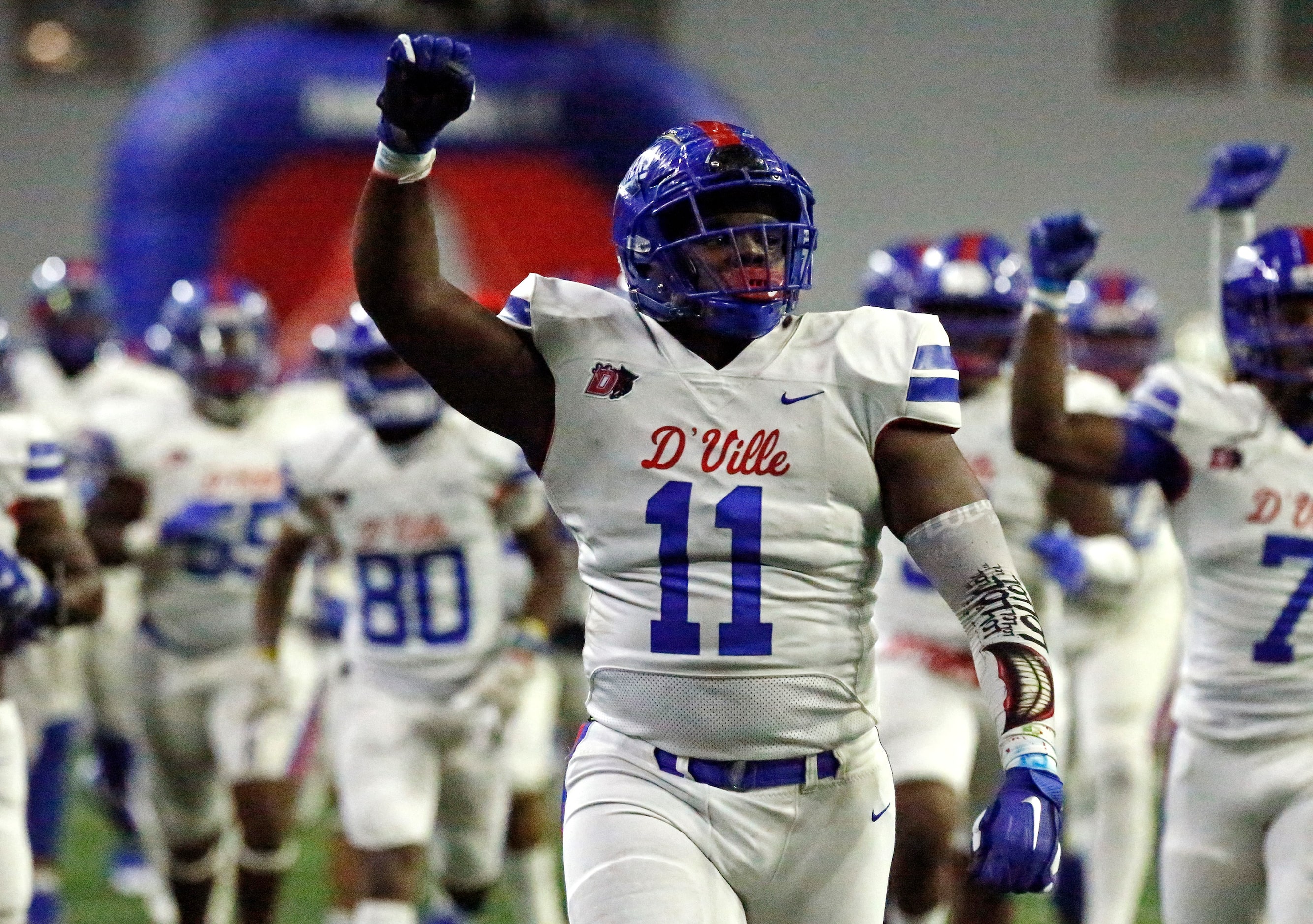 Duncanville High School defensive lineman Quincy Wright (11) leads his team onto the field...