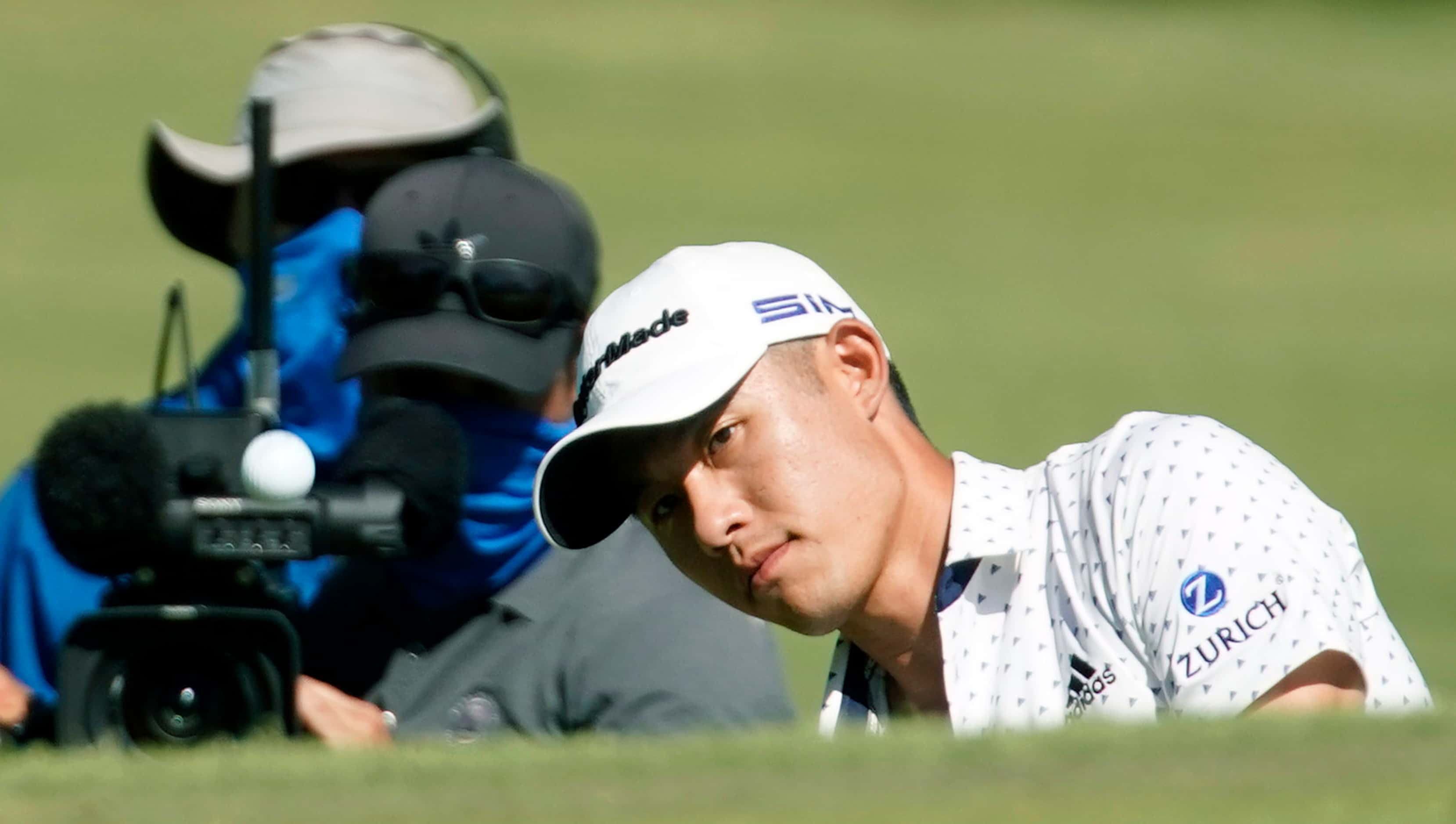 With a television camera over his shoulder PGA Tour golferCollin Morikawa chips onto the...
