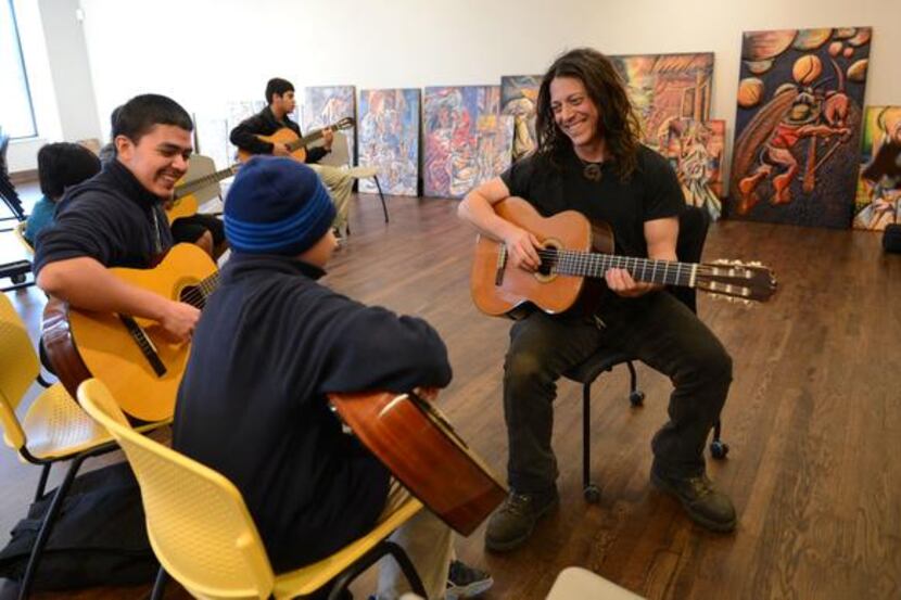 
Instructor Kenny Withrow gives a guitar lesson to brothers Jose Christopher Torres (left),...