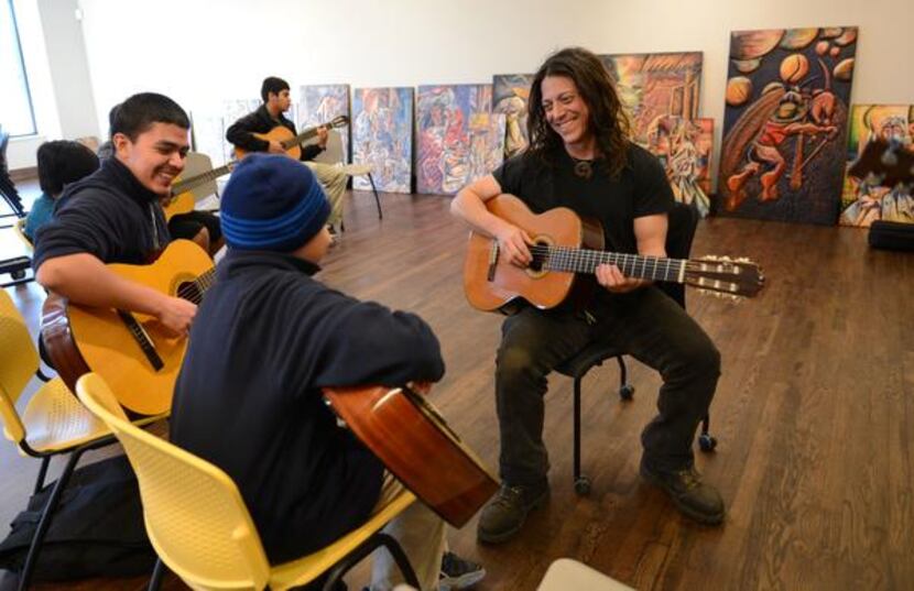 
Instructor Kenny Withrow gives a guitar lesson to brothers Jose Christopher Torres (left),...