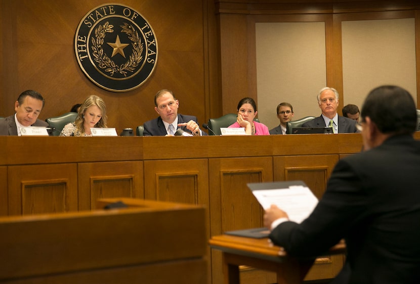 Texas protective services chief Henry "Hank" Whitman, right, shown testifying to the Senate...