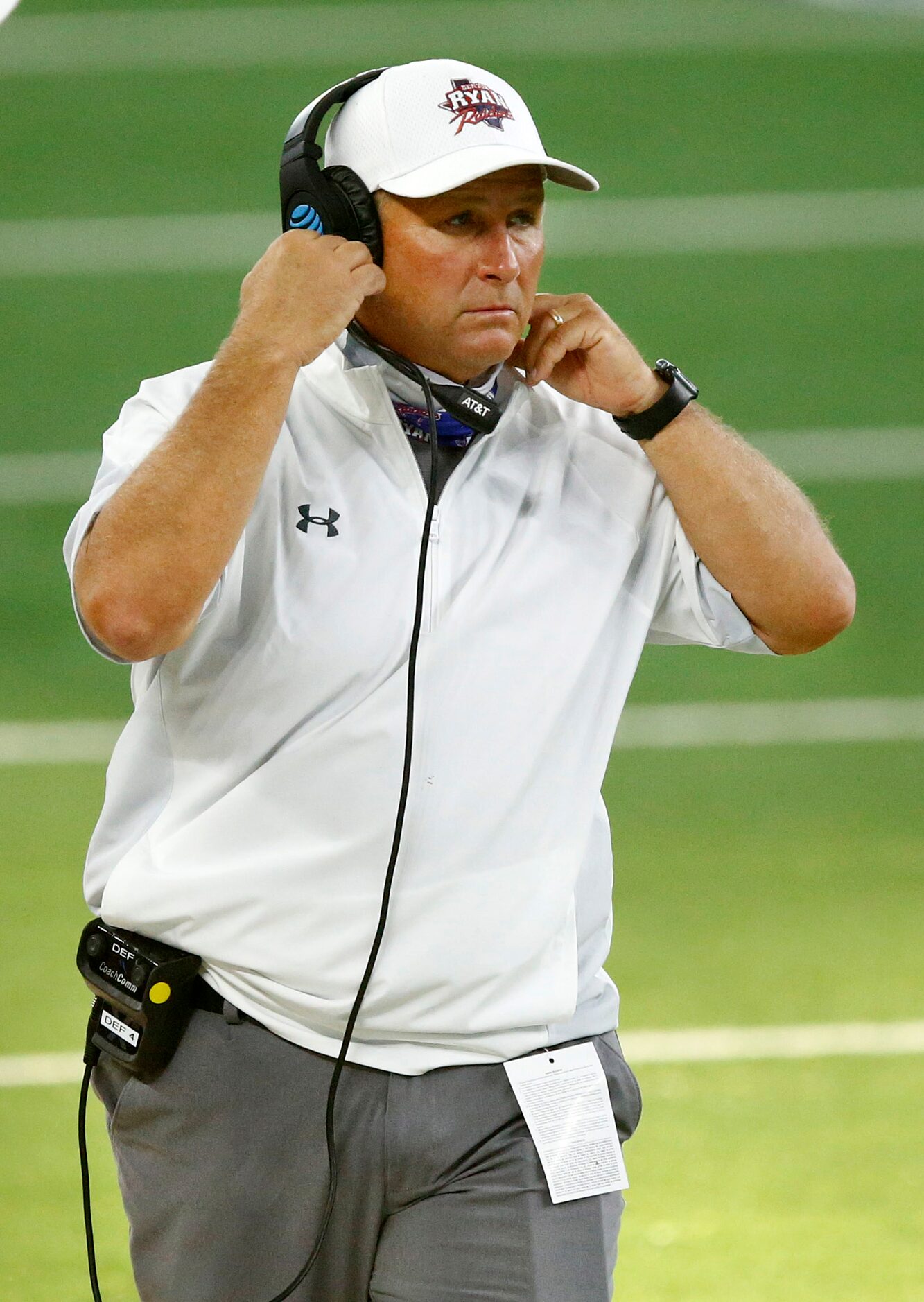 Denton Ryan head coach Dave Henigan adjusts his mask as he and his team face Arlington...