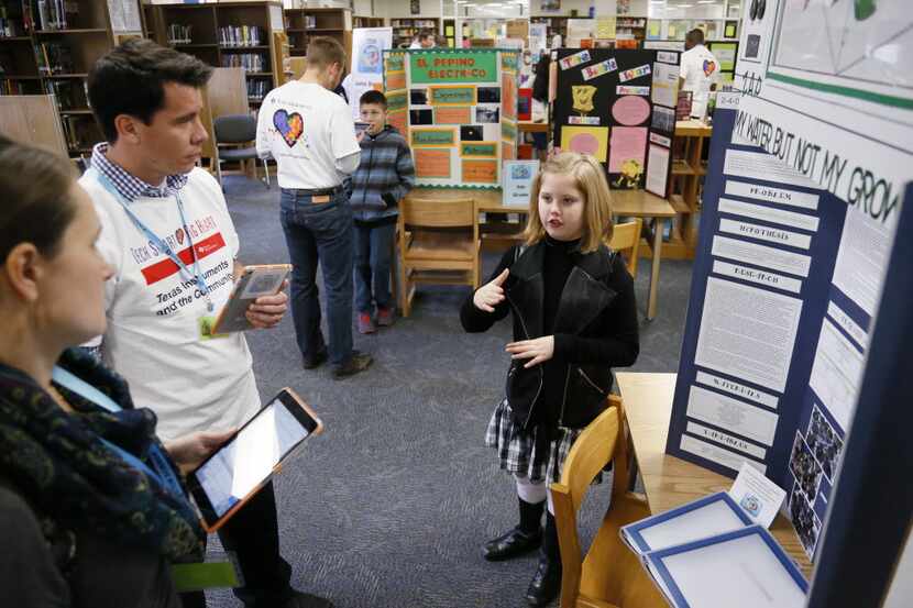 Josey Edgar, a fourth-grader at Dealey Montessori Academy, presents her science project to...