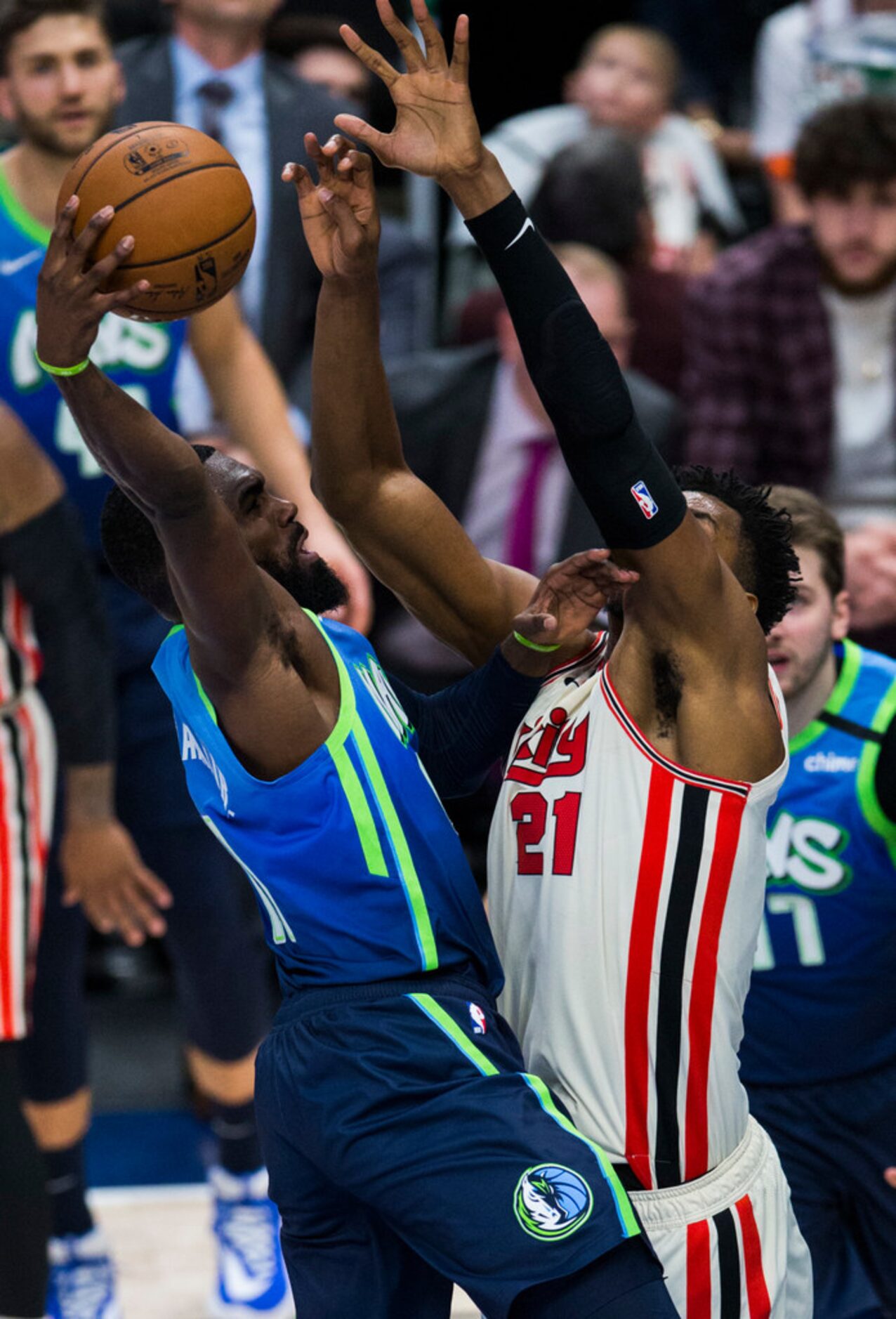 Dallas Mavericks guard Tim Hardaway Jr. (11) goes up for a shot over Portland Trail Blazers...