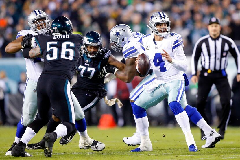 FILE - Cowboys quarterback Dak Prescott (4) looks for a receiver as he bounces around in the...